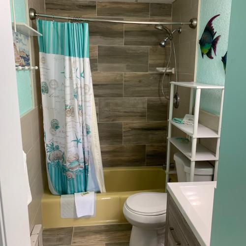 a bathroom with a toilet and a shower curtain at Roman Holiday Resort in North Wildwood