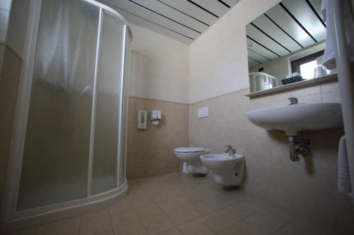a bathroom with a shower and a toilet and a sink at Hotel Fioroni in Bellagio