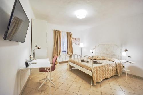 Schlafzimmer mit einem Bett, einem Tisch und einem Schreibtisch in der Unterkunft Casa Laurentius in Pisa