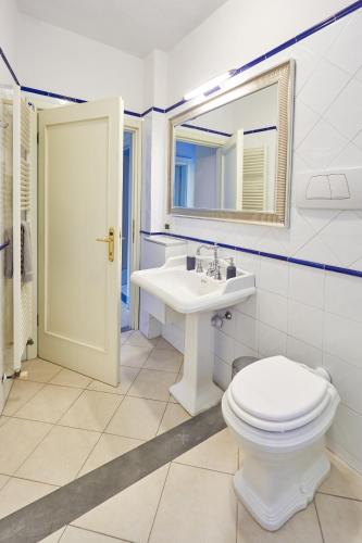 a bathroom with a toilet and a sink and a mirror at Casa Laurentius in Pisa