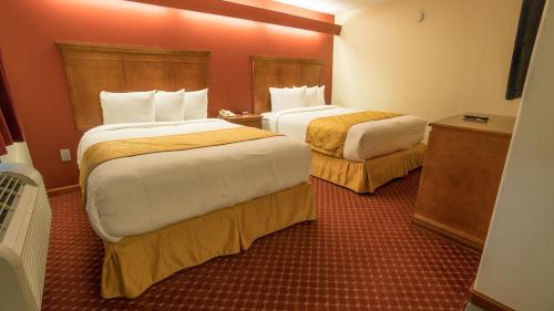 A bed or beds in a room at Shepherd Mountain Inn & Suites