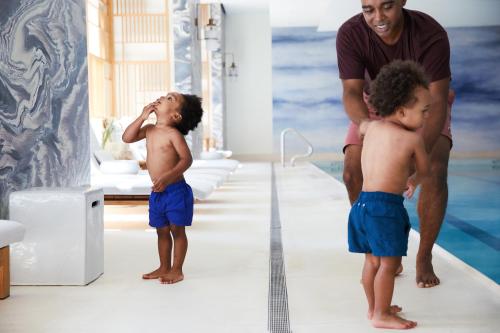 a man and two young boys standing in a bathroom at Four Seasons Hotel New York Downtown in New York