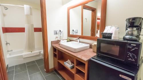 a bathroom with a sink and a microwave at Shepherd Mountain Inn & Suites in Pilot Knob