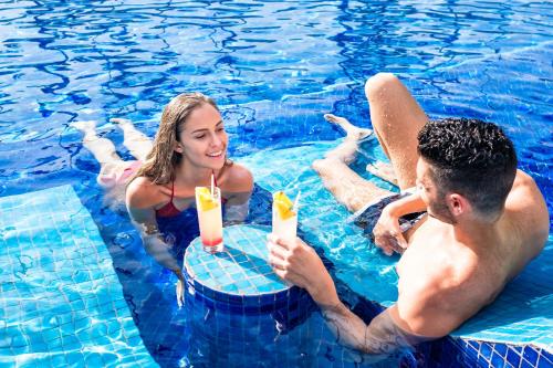 
a man and a woman sitting in a pool of water at Barceló Bávaro Beach - Adults Only All Inclusive in Punta Cana
