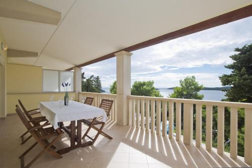 a dining room with a table and chairs on a balcony at Villa Malisko in Hvar