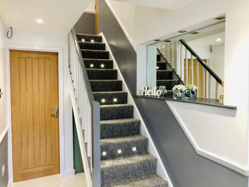 a staircase in a house with a wooden door at Oxford Studios in Kidlington