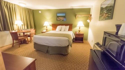 a hotel room with a large bed and a table at Fort Davidson Hotel in Pilot Knob