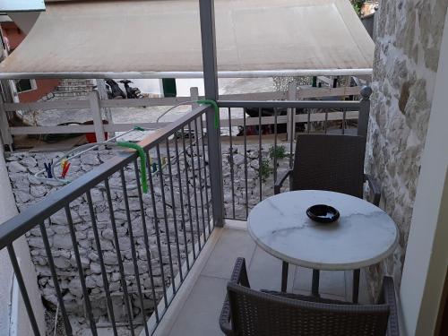 a white table and chairs on a balcony with a table at Paraskevi's Luxury Studios in Parga