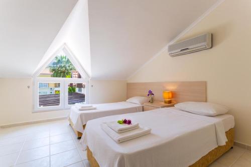 a bedroom with two beds and a window at Number 8 Olivia Apartments in Oludeniz