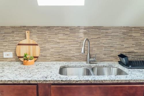 un comptoir de cuisine avec un évier et une planche à découper en bois dans l'établissement Spacious 2BR Apartment near Airport - Central Charming, à Dunning