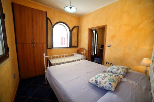 a bedroom with a bed and two windows at Villetta mare Salento in Patù