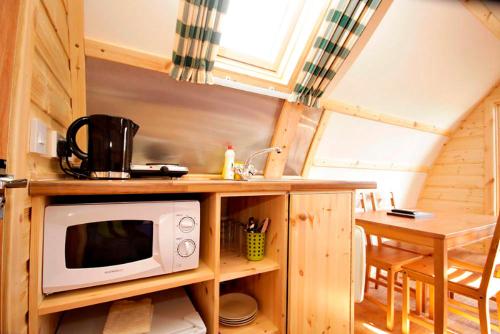 a kitchen with a microwave on a counter with a table at Causeway Coast Wigwams in Bushmills