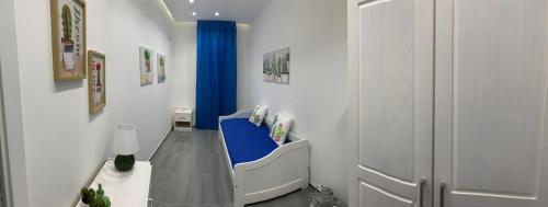 a hallway with a blue chair in a room at Deluxe Home appartamento in Sciacca