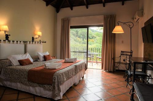 a bedroom with a bed and a balcony with a table at Hotel Selva Montana in San Lorenzo