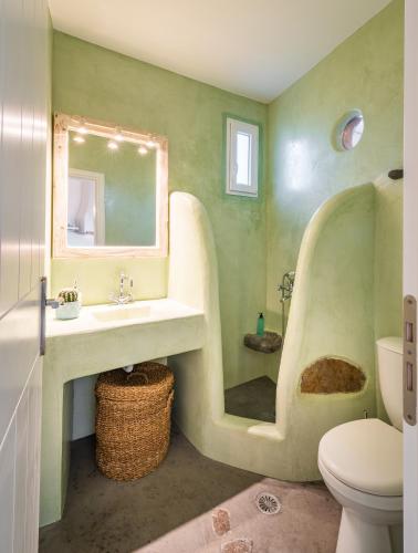 a bathroom with a sink and a toilet and a mirror at Klimata House - Private Jacuzzi Pool & BBQ Villa in Vlychada