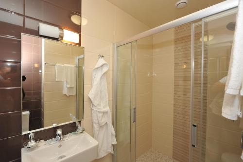 a bathroom with a shower and a sink and a mirror at Rest House in Volgograd