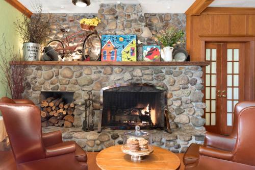 a stone fireplace in a living room with a table and chairs at The La Conner Inn in La Conner
