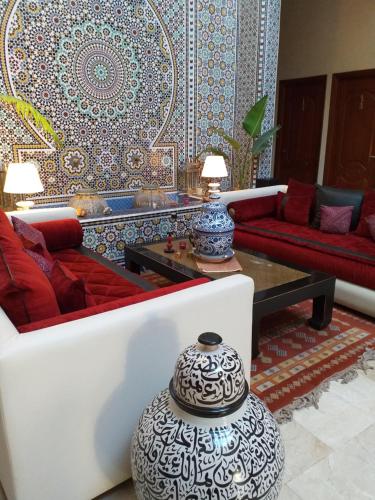 a living room filled with furniture and a fire place at Riad Passiflora in Fez