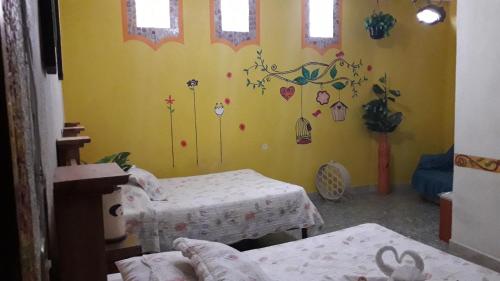 a room with two beds and a yellow wall at Hotel Colonial in Yautepec