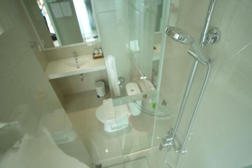 a bathroom with a shower and a toilet and a sink at Sunwood Hotel Arianz Mataram in Mataram