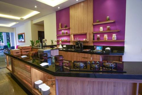 a kitchen with purple walls and a counter top at Sunwood Hotel Arianz Mataram in Mataram