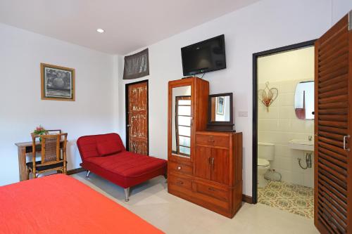 a bedroom with a red bed and a red chair at 155 SalaCoco in Ban Krut