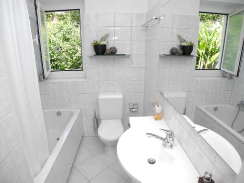 y baño blanco con aseo, bañera y lavamanos. en Casa Albaredo App 2309, en Brione sopra Minusio