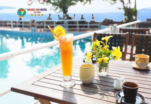 una bebida en una mesa junto a la piscina en Hoang Yen Hotel en Quy Nhon