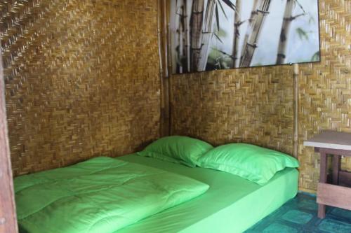 een bed met groene kussens in een bakstenen muur bij Bali Tree House Pelangi in Bedugul