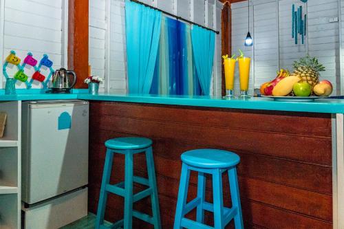 a kitchen with two blue stools at a counter at Baan Kiao in Haad Yao