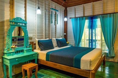 une chambre avec un lit, un miroir et une table dans l'établissement Baan Kiao, à Haad Yao