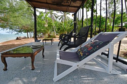 a porch with a chair and a coffee table at 155 SalaCoco in Ban Krut