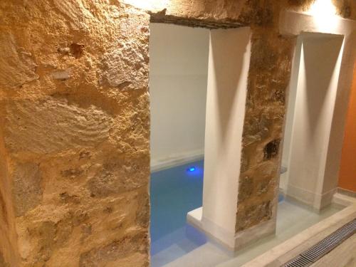 una camera con un muro in pietra e una piscina di Antica Canea Luxury Rooms a Chania