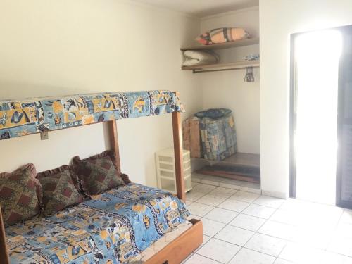 ein Schlafzimmer mit einem Etagenbett und einem Sofa in der Unterkunft Acomodação no paraíso in Ubatuba