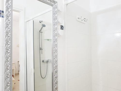 baño blanco con ducha y espejo en B&B Lido, en Gallipoli