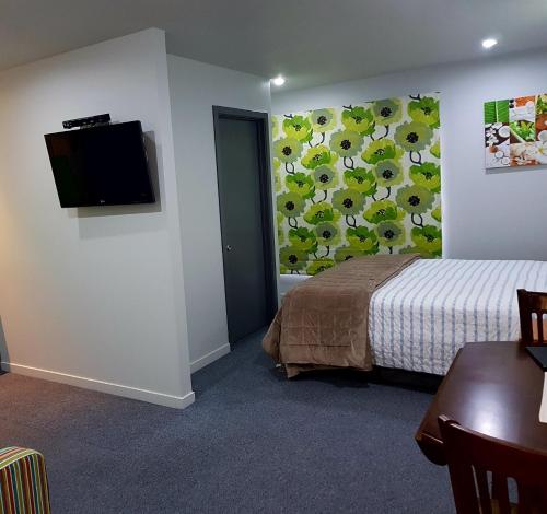 a bedroom with a bed and a tv on a wall at Anchor Down Bed & Breakfast in Picton