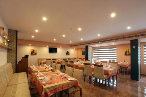 a restaurant with tables and chairs in a room at Hotel Park Residency Thrissur in Trichūr