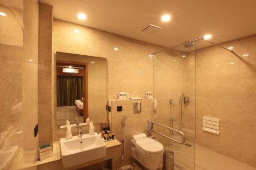 a bathroom with a toilet and a sink and a shower at Hotel Park Residency Thrissur in Trichūr