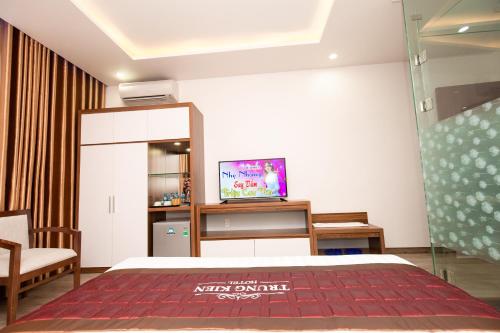 a hotel room with a bed and a tv at TRUNG KIÊN HOTEL in Hai Phong