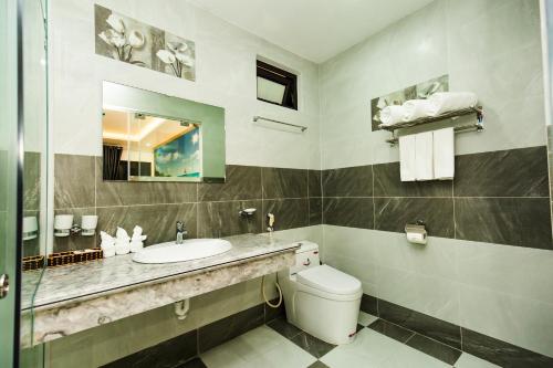 a bathroom with a sink and a toilet and a mirror at TRUNG KIÊN HOTEL in Hai Phong