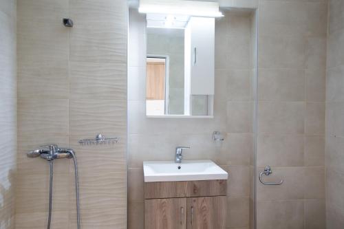 une salle de bain avec un lavabo et une douche avec un miroir dans l'établissement DTS apartment, à Réthymnon