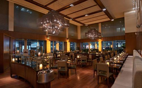 a dining room with tables and chairs and chandeliers at Park Hyatt Zurich – City Center Luxury in Zürich