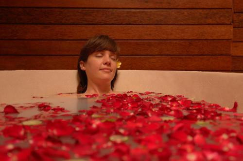 a woman is looking at a pile of red roses at Sri Ratih Cottages, CHSE Certified in Ubud