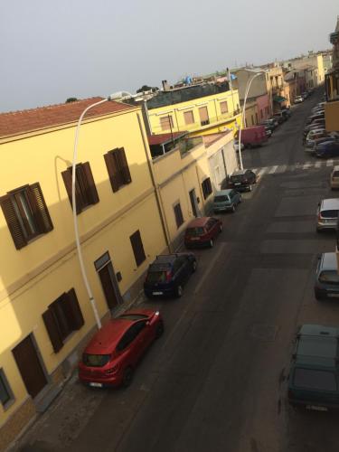 eine Gruppe von Autos, die auf einer Straße neben Gebäuden geparkt sind in der Unterkunft Laura's house in Cagliari