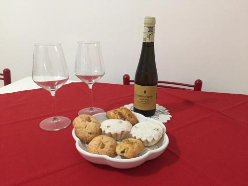 einen Teller Kekse und eine Flasche Wein auf dem Tisch in der Unterkunft Laura's house in Cagliari