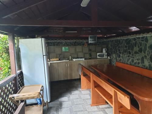 a kitchen with a wooden table and a refrigerator at Villa Mugur in 2 Mai