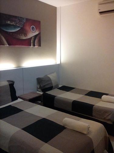 a room with two beds and a painting on the wall at Rivero Boutique Hotel Melaka in Melaka