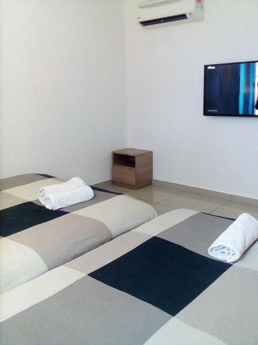 a room with two beds and a flat screen tv at Rivero Boutique Hotel Melaka in Melaka