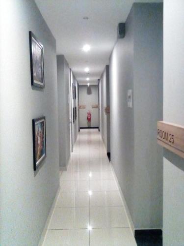 a hallway with a long corridor with white tile floors at Rivero Boutique Hotel Melaka in Melaka