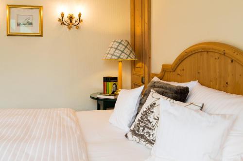 ein Schlafzimmer mit einem Bett mit weißen Kissen und einer Lampe in der Unterkunft Seitner Hof in Pullach im Isartal